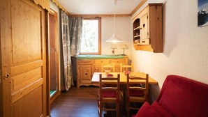 Une pièce chaleureuse, meublée de meubles en bois, avec une table à manger et un canapé rouge.