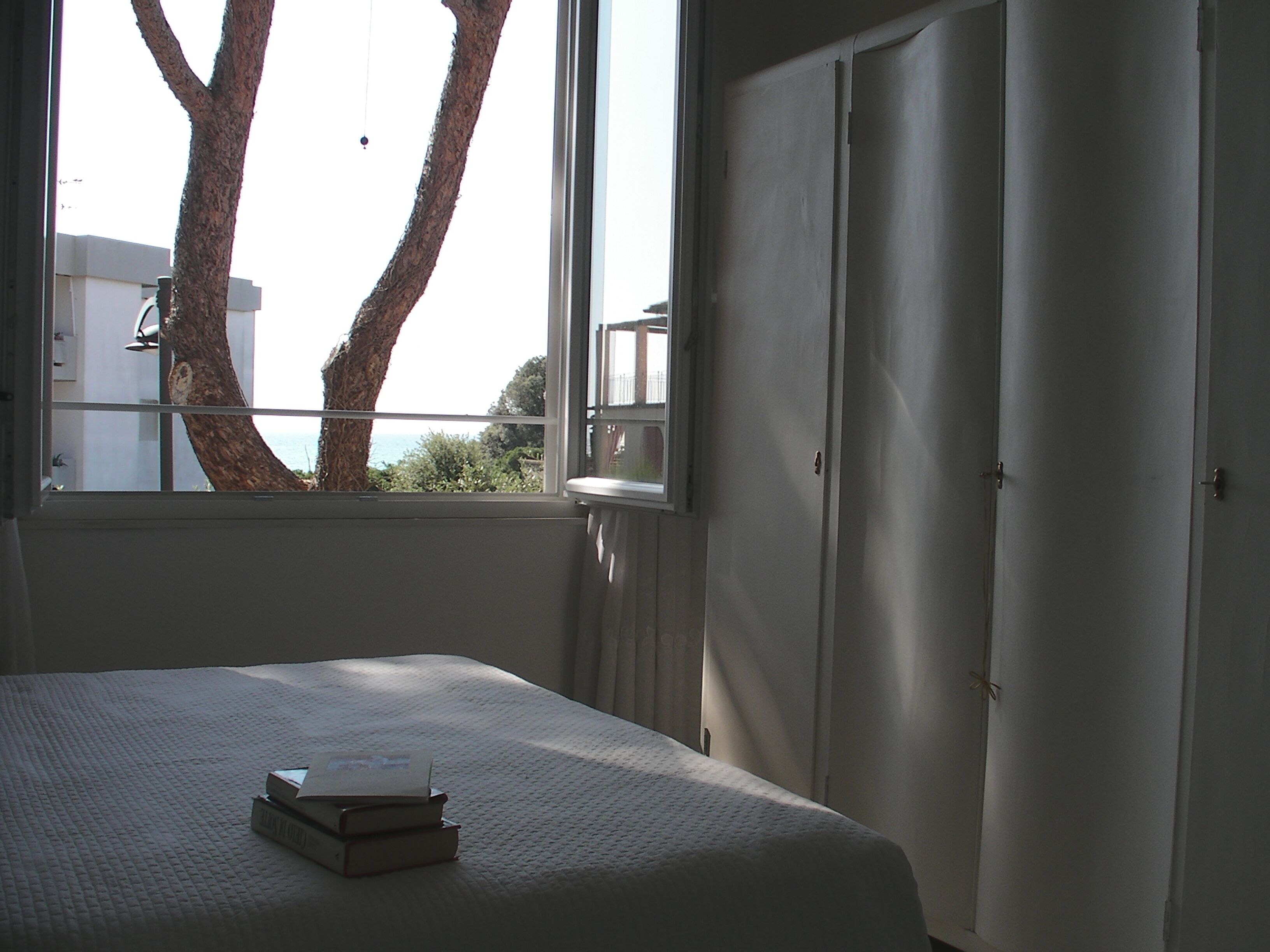 Un dormitorio con cama, ventana y armario.