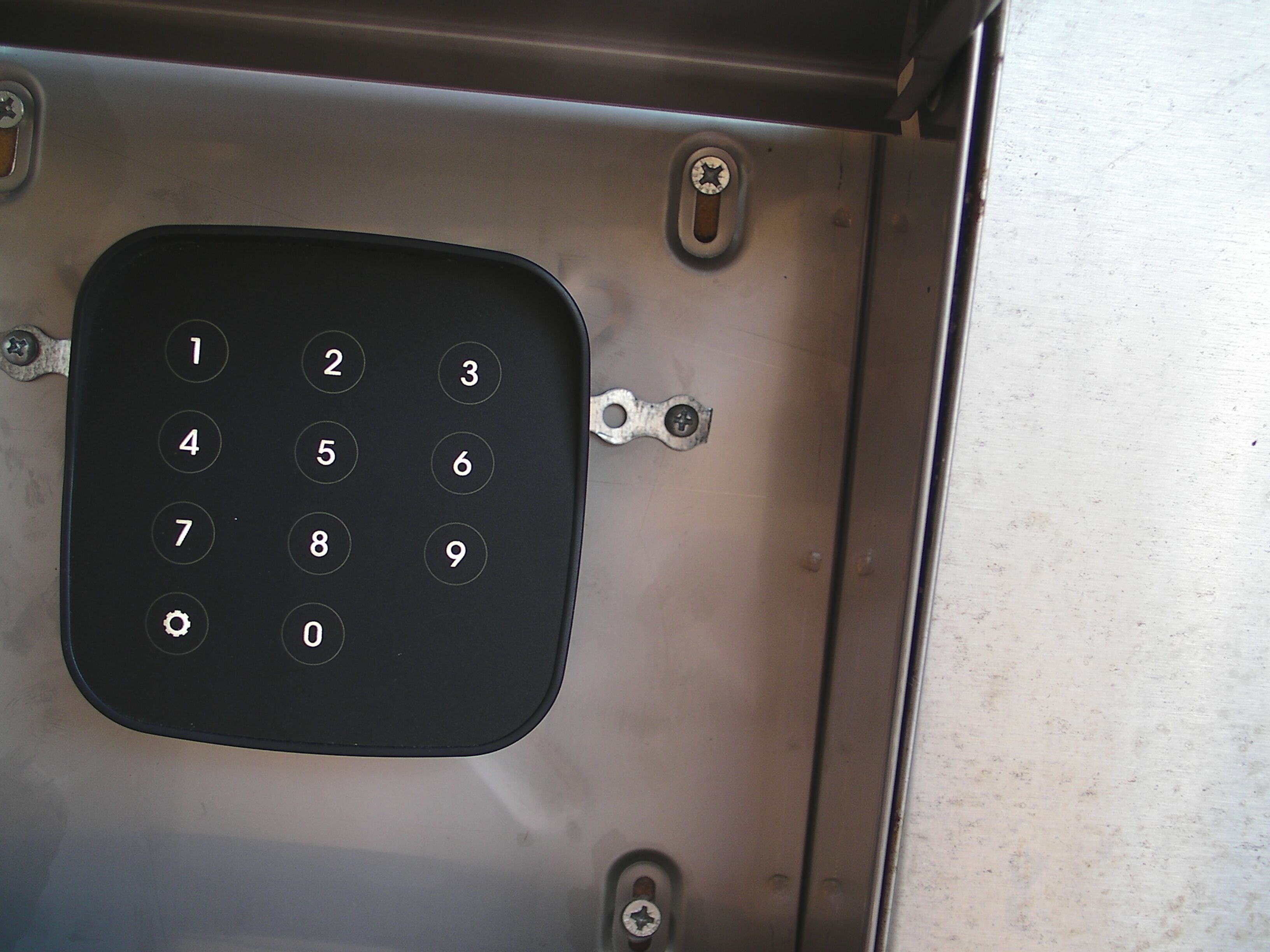 Un clavier numérique avec les chiffres de 0 à 9 et un mécanisme de verrouillage.