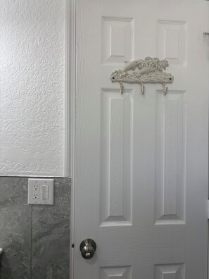 A white door with a textured wall and a marble-like backsplash.