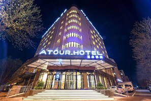 A hotel with a prominent sign, multiple floors, and a well-lit entrance. - Atour Hotel Xichang Road Langfang (Langfang)