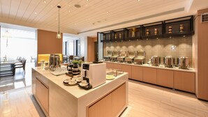 Una cocina moderna con una isla central, electrodomésticos integrados y una barra para desayunos.