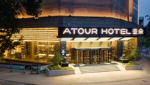 The exterior of the Atour Hotel with a modern facade, illuminated signage, and a gated entrance. - Atour Hotel Daguanyuan Jinan (Jinan)