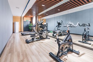 A gym with stationary bikes, a treadmill, and a mirrored wall. - Atour Hotel Changhong North Road Xiangyang (Xiangyang)