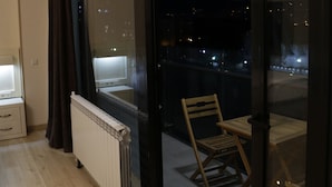 Un balcon avec vue sur la ville la nuit.