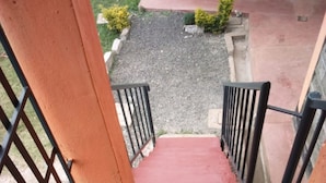A staircase with red steps leading down to a tiled area. - Gee -Thorn Hotel (Chaka)