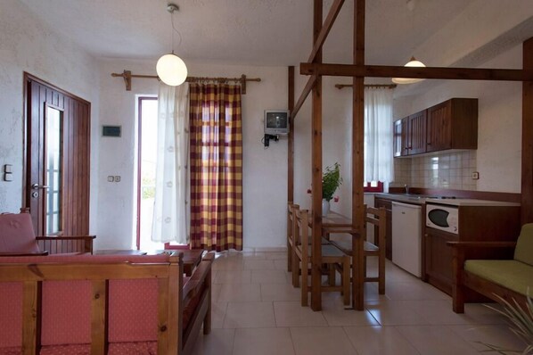 A compact living space with a dining area, kitchen, and a small seating area.