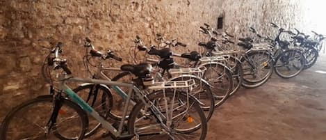 Bicicletas estacionadas em um túnel com parede de tijolos rústica.