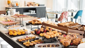 Un bufé con diversas opciones de pasteles, postres y pan.