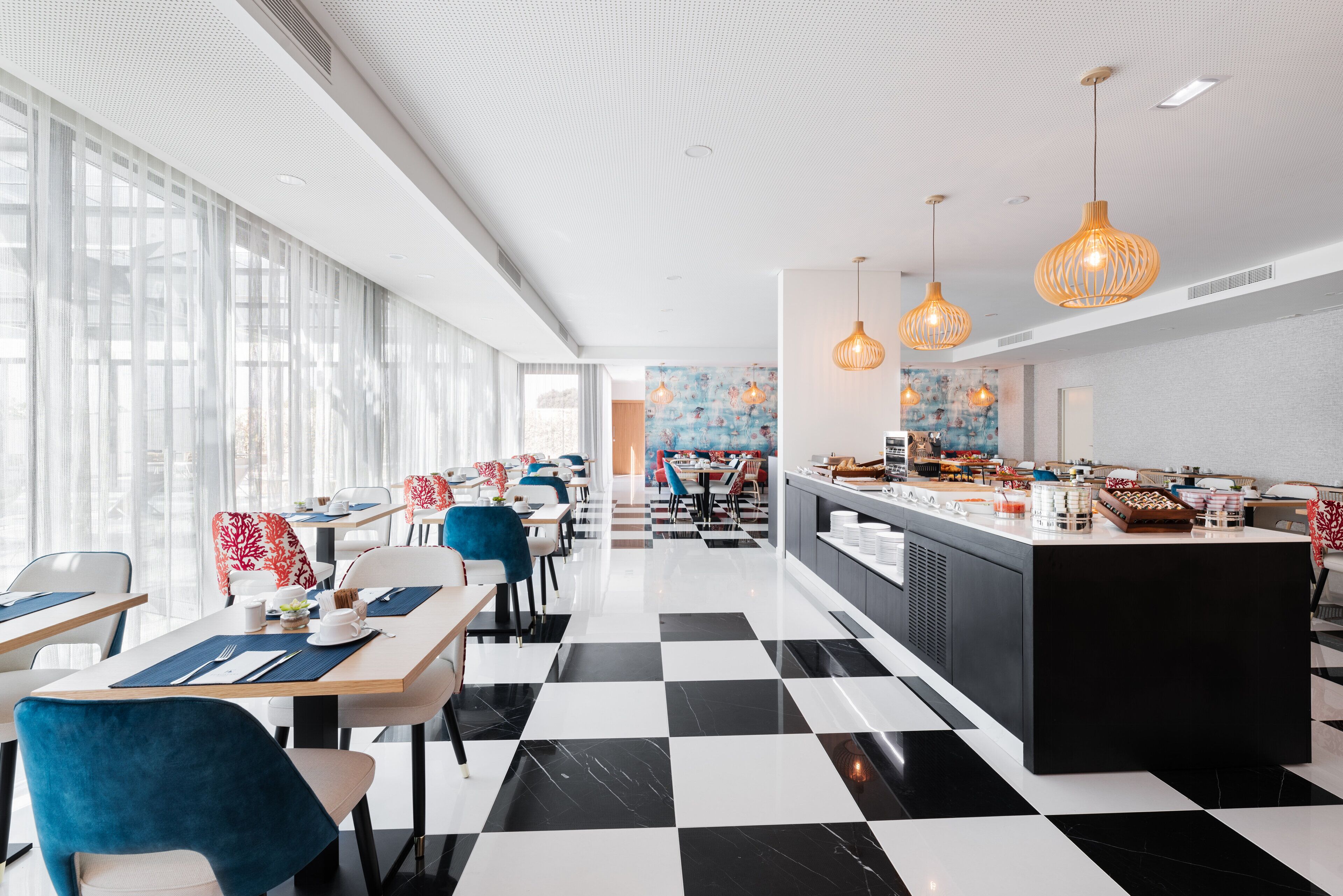 A modern restaurant with a checkered floor, white walls, and a central island with food displays.