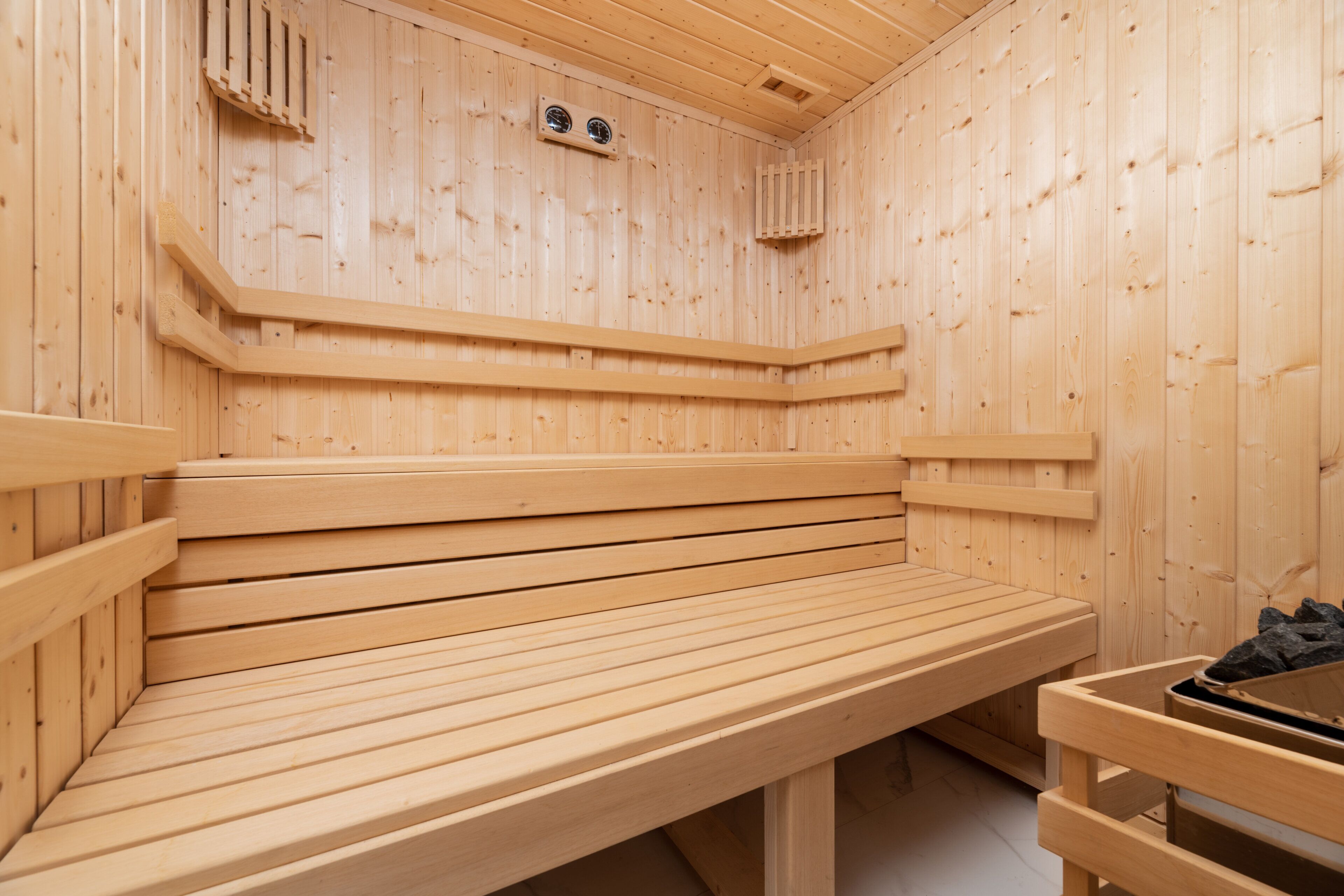 Eine Holzsauna mit Bänken und einer Sitzbank.