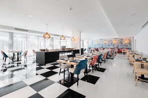 A spacious dining area with checkered flooring, modern chairs, and pendant lighting. - Eurostars Matosinhos (Matosinhos)