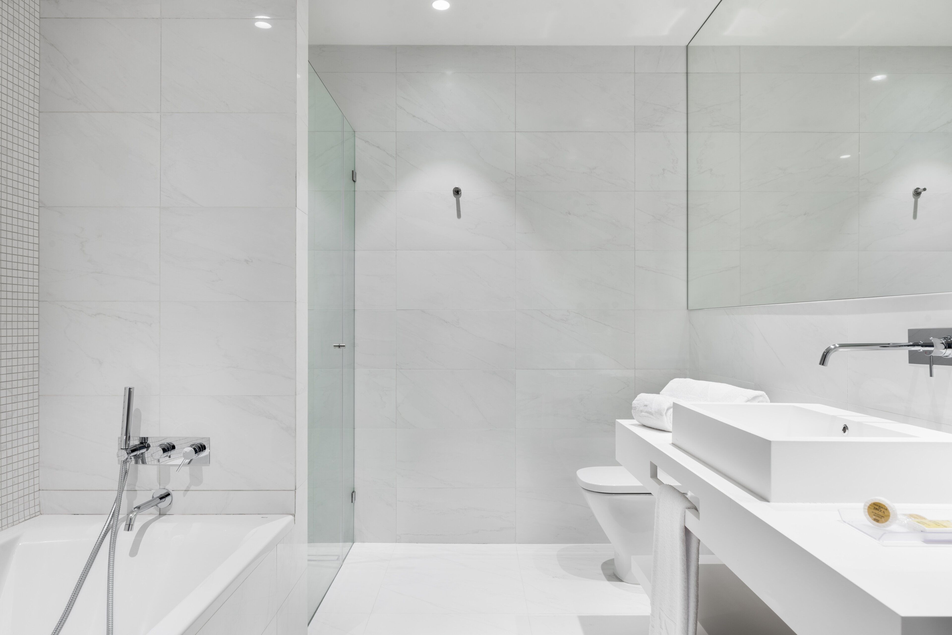A modern bathroom with a bathtub, toilet, and sink.