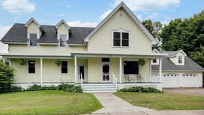 A two-story house with a front porch, a garage, and a well-maintained lawn. - Historic 1880s Home (Osceola)