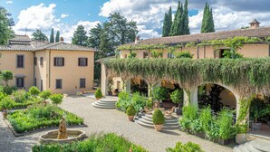 A courtyard with a fountain, potted plants, and outdoor seating areas. - Casa Ruffino (Bagno a Ripoli)