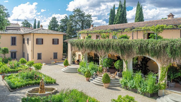 A courtyard with a fountain, potted plants, and outdoor seating areas. - Casa Ruffino (Bagno a Ripoli)