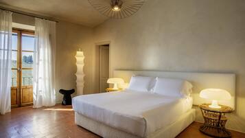 Une chambre spacieuse avec un grand lit, deux lampes de chevet et une vue sur l’extérieur grâce à une porte coulissante.