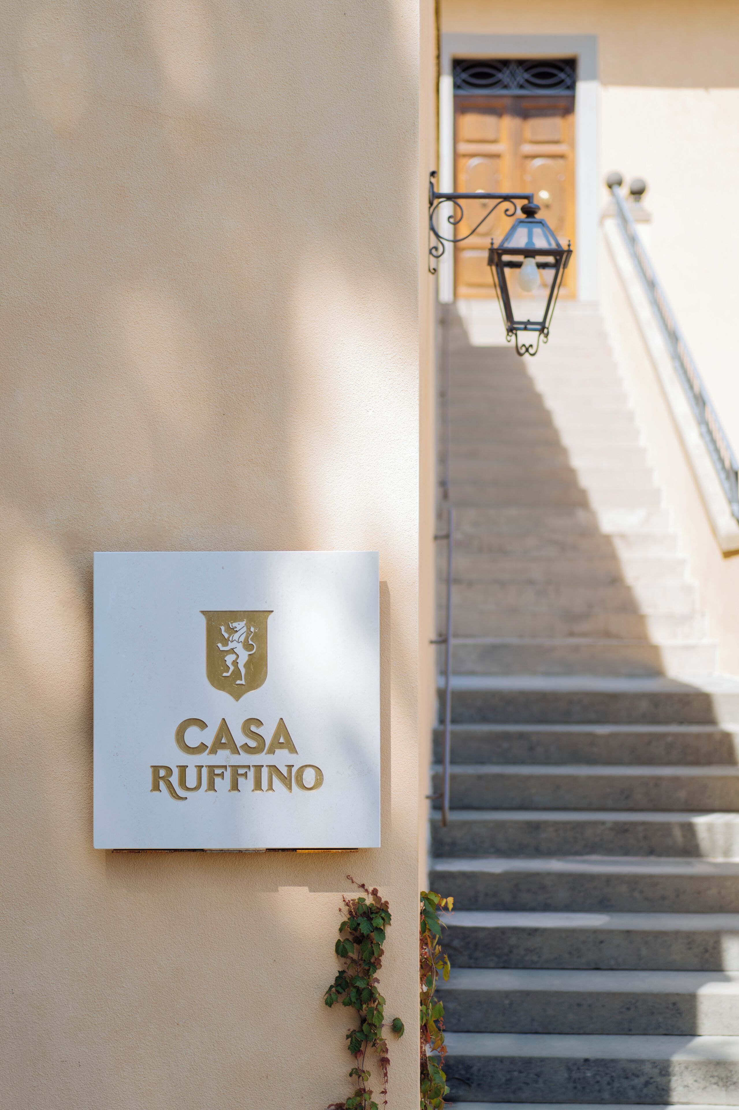 Un letrero que dice "Casa Ruffino" en una pared, con una escalera de fondo.
