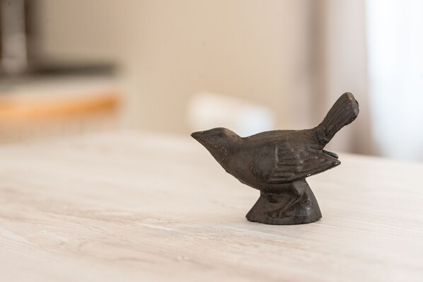Una pequeña figurina de pájaro sobre una superficie de madera.