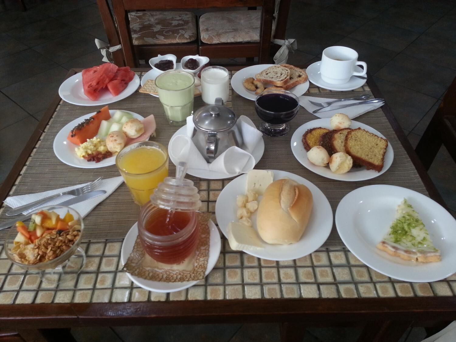 A breakfast table with various food items and drinks.
