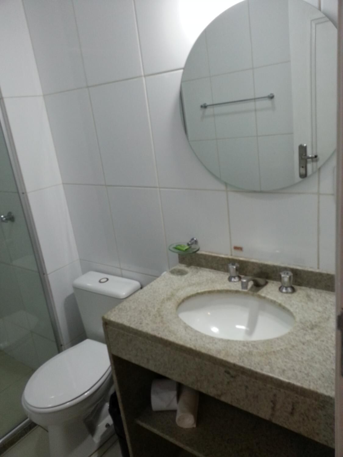 Un baño con inodoro, lavabo y espejo.