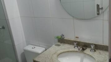 Un baño con inodoro, lavabo y espejo.