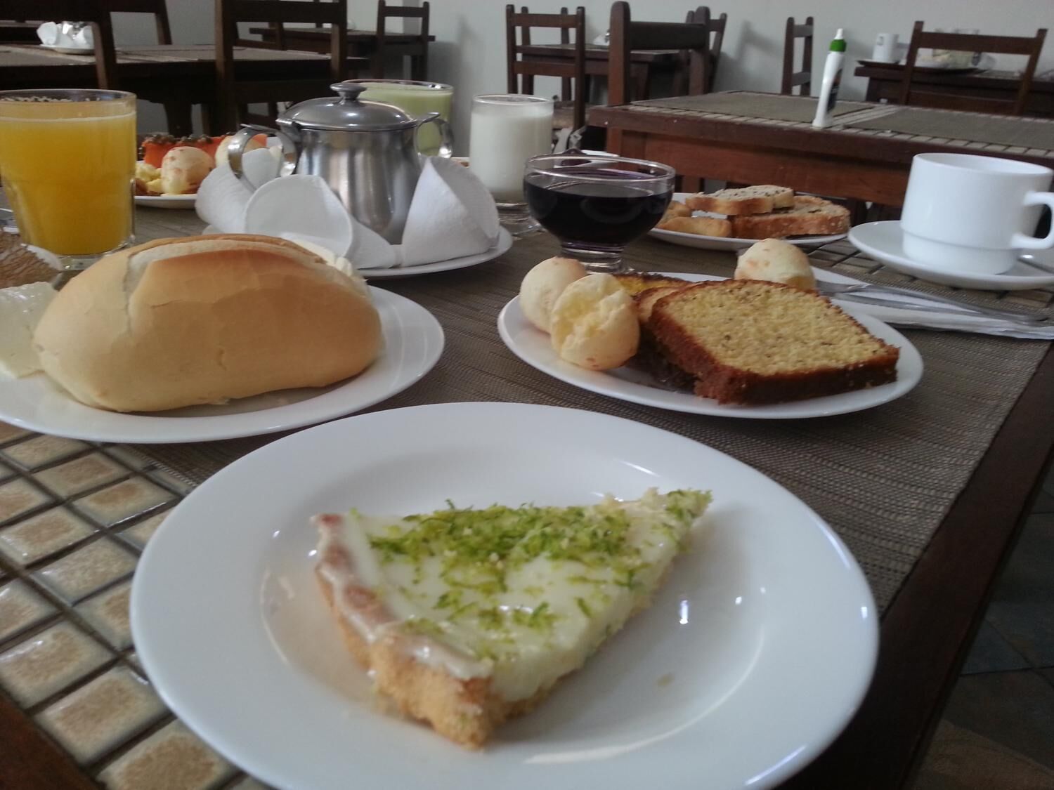Una mesa de desayuno con platos de comida, una taza de café y una jofaina.