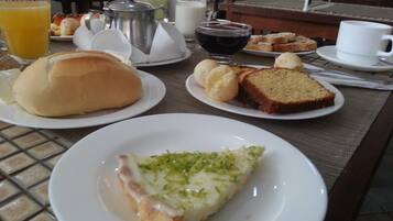 Une table de petit-déjeuner avec des assiettes remplies de nourriture, une tasse de café et un pichet.