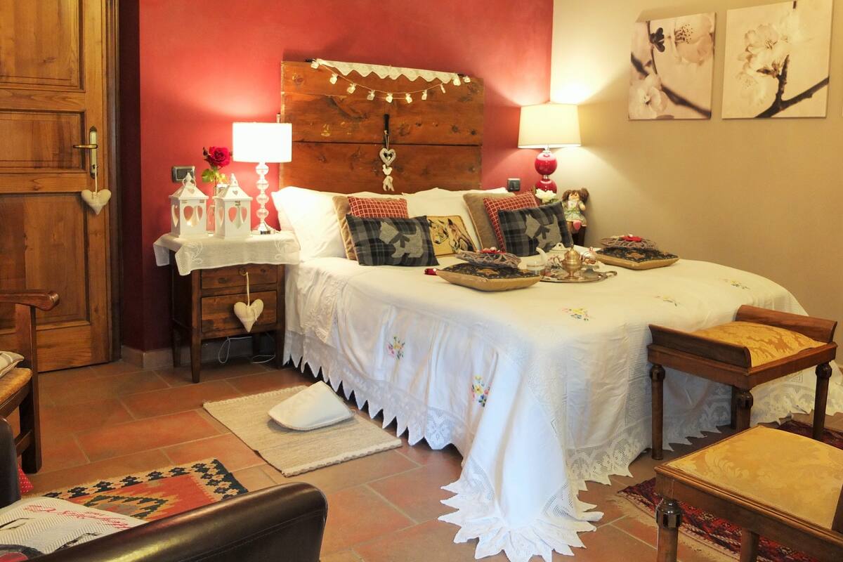 Une chambre confortable avec une tête de lit en bois, une table de chevet avec une lampe et un coussin décoratif.