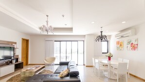 A modern living room with a sofa, TV, and dining area. - Victoria Village (Asunción)