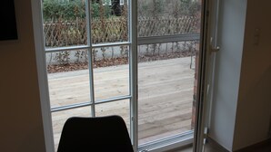 A room with a large sliding glass door leading to an outdoor patio. - Ferienwohnung Remise (Lübbenau/Spreewald)