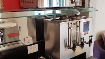Uma cozinha com máquina de café, vitrine de vidro e pia.