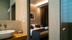 A hotel room with a large bathroom sink, a bed with a brown blanket, and a painting on the wall. - San Marco Antico Relais (Bitonto)