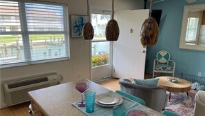 Una cocina moderna con una isla grande, un comedor con mesa redonda y vistas al exterior a través del ventanal.