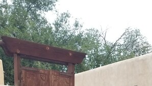 Puerta doble de madera con marco de madera y un pequeño ventanal en la parte superior.