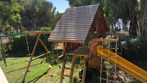 A wooden play structure with a slide, a ladder, and a swing set. - Splendid Valley & Sea View (Broumana)