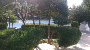 A landscaped area with neatly trimmed hedges, a paved walkway, and a variety of trees. - Splendid Valley & Sea View (Broumana)