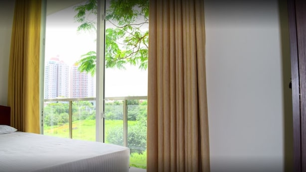 A hotel room with a large window, a bed, and curtains. - The Green' Apartments (Colombo)
