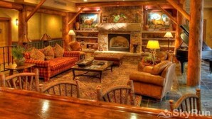 A cozy, rustic living room with a fireplace, wooden beams, and comfortable seating. - Premier 4 Bedroom Ski in, Ski out Vacation Rental at the Timbers With the Best Access to Skiing in Keystone (Keystone)