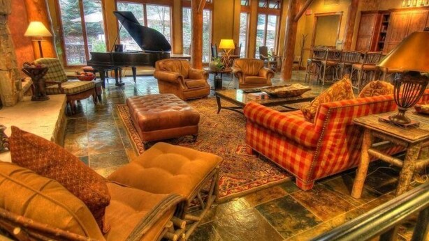 A spacious lobby with leather sofas, a grand piano, and a dining area with wooden tables and chairs. - Premier 4 Bedroom Ski in, Ski out Vacation Rental at the Timbers With the Best Access to Skiing in Keystone (Keystone)