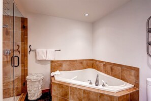 Ein Badezimmer mit freistehender Badewanne, einer Duschkabine und einem Handtuchhalter.
