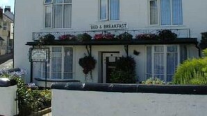 Un edificio de dos pisos con un letrero que dice "BED & BREAKFAST" sobre la entrada.