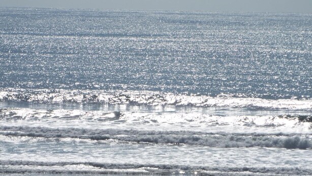 Una playa con olas y cielo despejado.