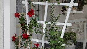 A white trellis with climbing plants and red flowers. - Ferienhaus Windspiel (Lübbenau/Spreewald)