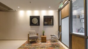 A lobby with two chairs, a patterned rug, and framed artwork on the wall. - Soho Style Moderno Studio las Mercedes (Asunción)