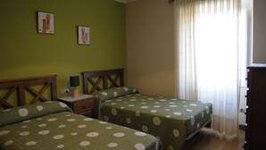 A room with two beds, a nightstand, a lamp, and a window with curtains. - Rustic house with sea views (Carnota)