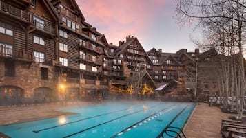 A pool area with a wooden building in the background.