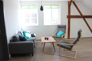 Departamento, 2 habitaciones, sauna | Área de sala de estar | Televisión de pantalla plana y chimenea 