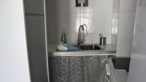 A small kitchen with a sink, a faucet, and a bottle of dish soap. - Ferienwohnung Brunnenblick (Lübbenau/Spreewald)