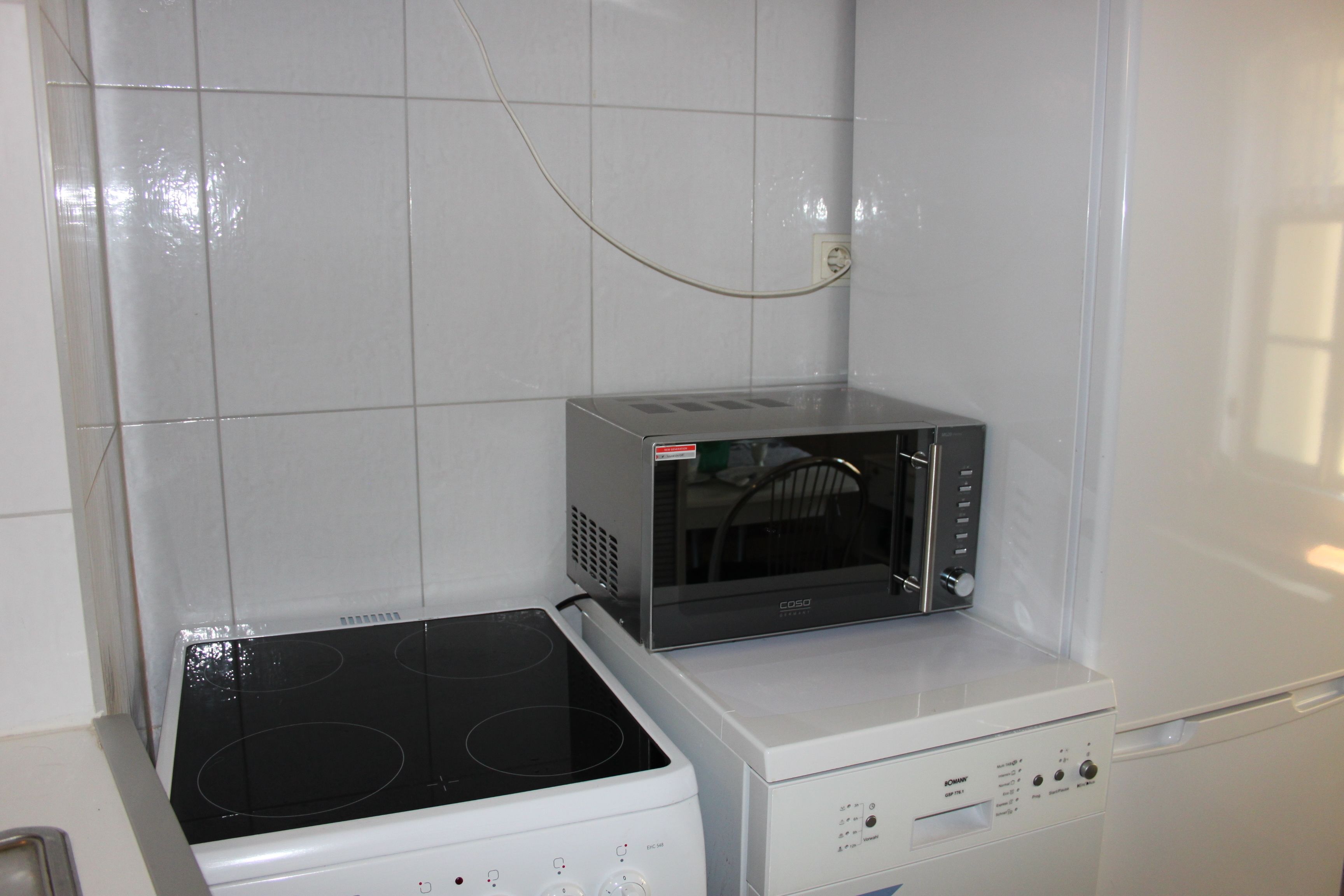 Una cucina con piano cottura, microonde e forno integrato.
